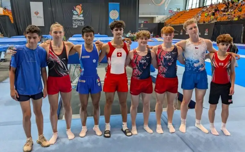 Finaliści turnieju stoją razem w jednym rzędzie trzymając się za ramiona, wszyscy w strojach reprezentacyjnych swoich krajów.