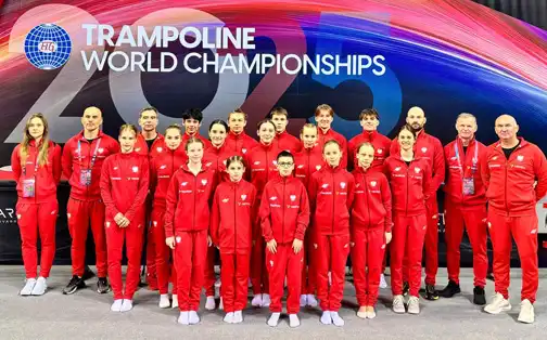 Duża grupa zawodników w dresach reprezentacji Polski na tle napisu "Trampoline World Championships 2025"